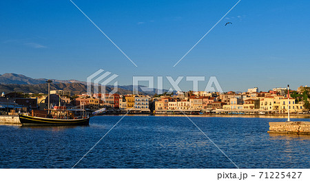 Beautiful view of Old Venetian harbour of Chania, Crete, Greece, quayside, tourist boats by piers in early morning. Cretan mountains in background. 71225427