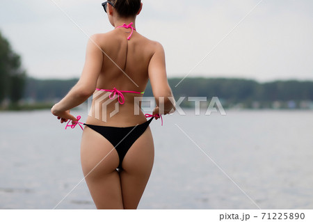 Fit hot woman taking off swimsuit panties - Stock Photo [71225890