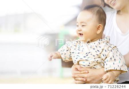 お母さんに抱っこされてはしゃいでいる赤ちゃん 71226244