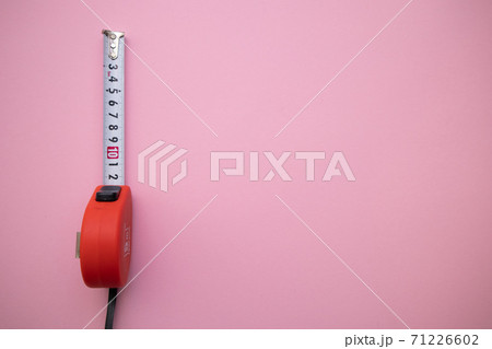 Industrial red measuring tape on pink background, top view. Free space for text 71226602