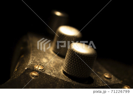 Bass guitar closeup on volume knob in music studio shot at golden hour 71226799