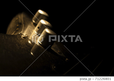 Bass guitar closeup on volume knob in music studio shot at golden hour 71226801