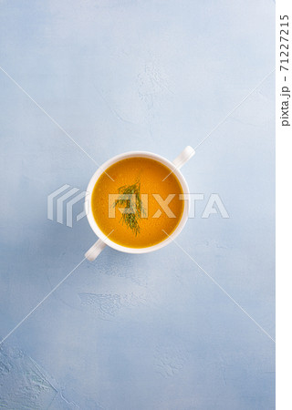 Bouillon with herb leaf in bowl on blue background Bouillon with herb leaf in bowl on blue background 71227215