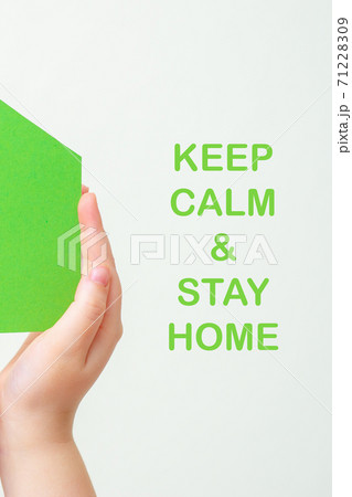 Hands holds green paper house. 71228309