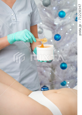 Cosmetologist holds jar with sugaring paste Cosmetologist holds jar with sugaring paste 71228347