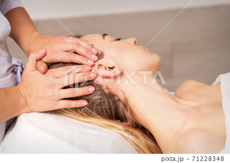 Young woman receiving head massage Young woman receiving head massage 71228348