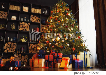 Christmas interior with bookshelves, great christmas tree, boxes in studio Christmas interior with bookshelves, great christmas tree, boxes in studio 71228598