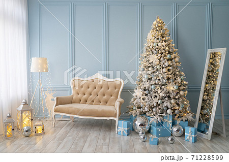 Stylish Christmas interior decorated in blue colors. Comfort home. Sofa with beige fabric upholstery Stylish Christmas interior decorated in blue colors. Comfort home. Sofa with beige fabric upholstery 71228599