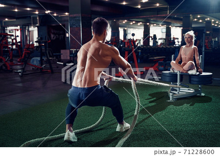 Fitness man working out with battle ropes at gym 71228600