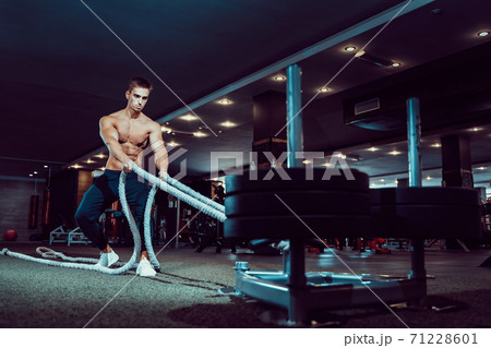 Fitness man working out with battle ropes at gym Fitness man working out with battle ropes at gym 71228601