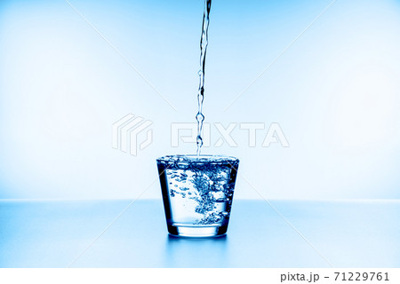 water splashing from glass isolated on blue background water splashing from glass isolated on blue background 71229761