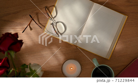 Top view of workspace with opened notebook, glasses and decorations 71229844