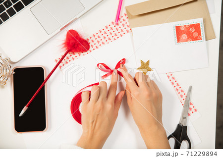 Woman making greeting card for New Year and Christmas 2021 for friends or family, scrap booking, DIY 71229894