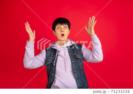 Senior woman isolated on red background. Tech and joyful elderly lifestyle concept 71233238