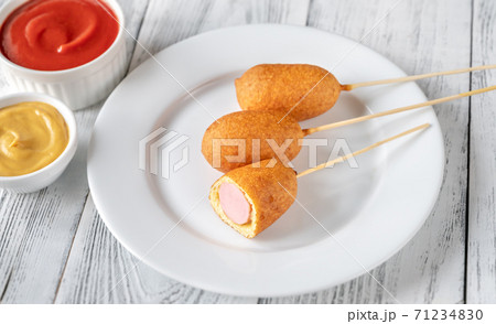 Corn dogs on white serving plate Corn dogs on white serving plate 71234830
