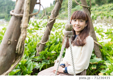 A woman in a field of calla lilies in Taiwan, Asia. 71236435