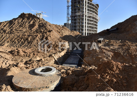 Laying concrete manholes and heating drain pipes and for stormwater system at construction site. 71236616