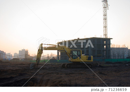 Excavator at construction site on a background of a construction cranes and building.  71236659