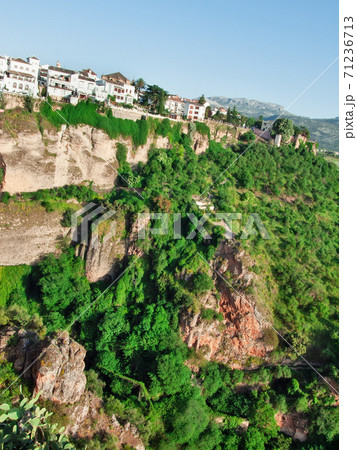 Panoramic view at gorge with houses of New bridge in Ronda, one of the famous place in Andalucia. Andalusia, Spain Panoramic view at gorge with houses of New bridge in Ronda, one of the famous place in Andalucia. Andalusia, Spain 71236713