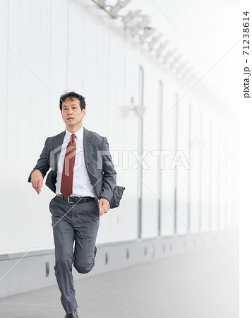全力で走るシニアビジネスマンの写真素材