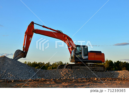 Excavator loads of stone and rubble for processing into cement or concrete for construction work  71239365