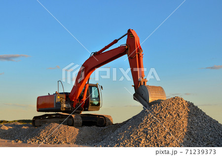 Excavator loads of stone and rubble for processing into cement or concrete for construction work  71239373