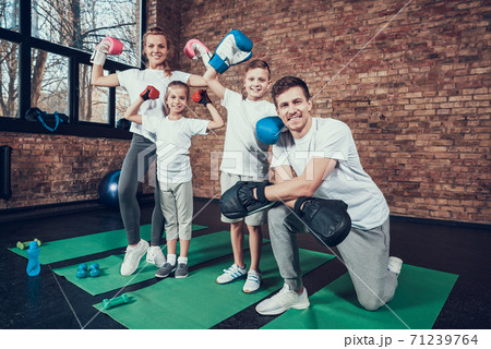 Dad kneels next to children in boxing gloves. Dad kneels next to children in boxing gloves. 71239764