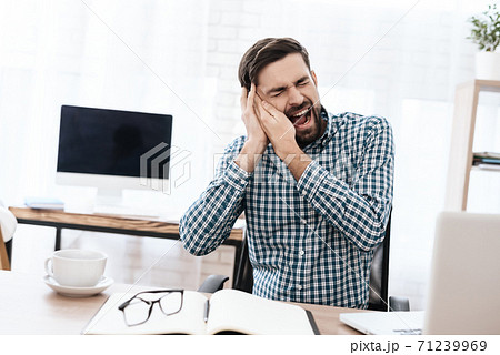 A man in shirt sits and screams from severe pain. A man in shirt sits and screams from severe pain. 71239969