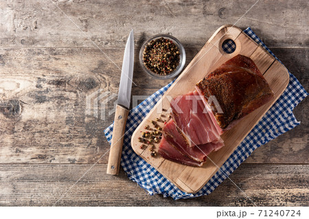 Dried and smoked meat on wooden table 71240724