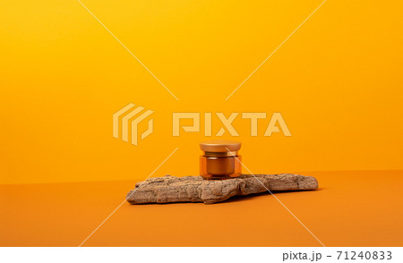 A jar of cream podium made of natural wood materials on a orange background 71240833