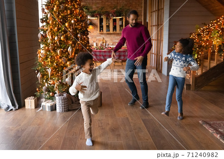 Happy African American father with kids dancing, celebrating Christmas together 71240982