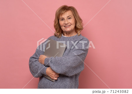 Confident mature woman with laptop looking at camera and smiling. Confident mature woman with laptop looking at camera and smiling. 71243082