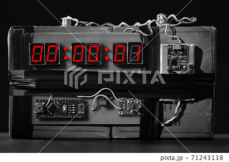 Terrorist threat. Explosives with detonator. Improvised explosive device. Bomb with a red timer on black background. Dynamite is going to explode or detonate per 1 second. Time bomb with clockwork. bw Terrorist threat. Explosives with detonator. Improvised explosive device. Bomb with a red timer on black background. Dynamite is going to explode or detonate per 1 second. Time bomb with clockwork. bw 71243138