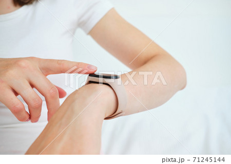 A young woman is at home and uses smart watches. A young woman is at home and uses smart watches. 71245144