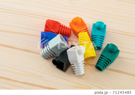 caps on a wire rj45 assorted bright blue, green on a wooden background 71245485