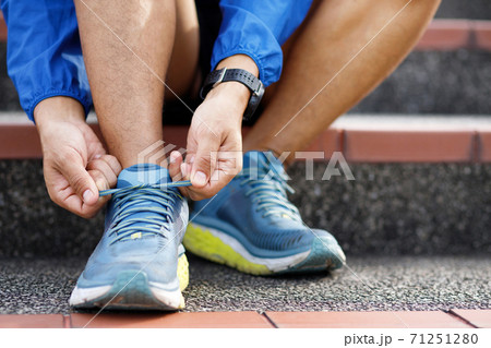 Runners tie their shoes on the running course. 71251280