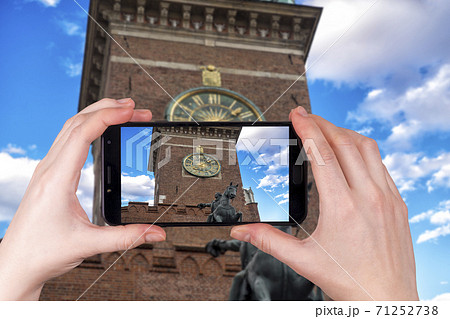 clock on the town hall tower on main square in Krakow close-up, Poland. tourist takes a photo 71252738