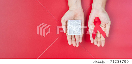 December World Aids Day Awareness month, Red Ribbon and condom on wood background for supporting people living and illness. Healthcare and safe sex concept 71253790
