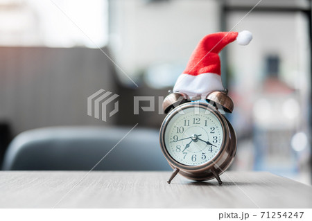 Merry Christmas with Miniature Santa Clause hat alarm clock and on table background. Holiday, Celebration, countdown and New Year concept Merry Christmas with Miniature Santa Clause hat alarm clock and on table background. Holiday, Celebration, countdown and New Year concept 71254247