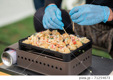 キャンプ場でたこ焼きを焼く男性 キャンプ場でたこ焼きを焼く男性 71254673