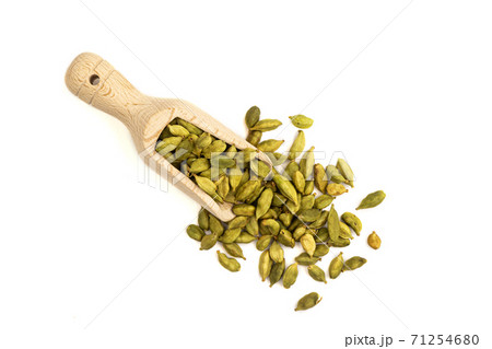 Isolated heap of cardamom seeds in a wooden scoop 71254680