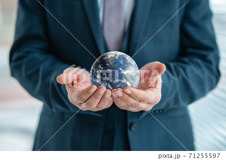 Businessman is holding world sphere. concept of beeing connected and ruling the world, global domination. Elements of this Image Furnished by NASA. Businessman is holding world sphere. concept of beeing connected and ruling the world, global domination. Elements of this Image Furnished by NASA. 71255597