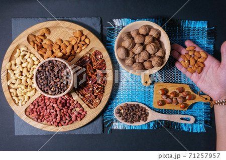 Nuts in a wooden plate. Pecans, almonds, cashews, peanuts, walnuts, pine nuts. flat lay Nuts in a wooden plate. Pecans, almonds, cashews, peanuts, walnuts, pine nuts. flat lay 71257957