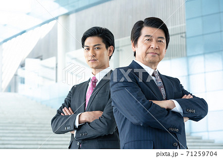 ビジネス　企業のロビーに立つ若い男性とミドルエイジの男性 71259704
