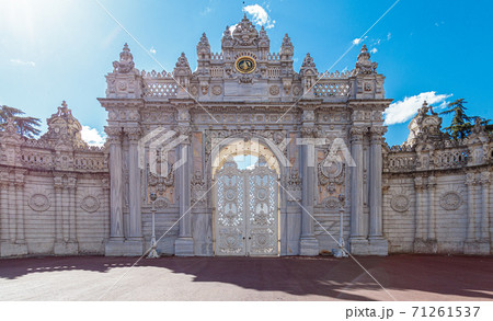 The luxurious North Gate of Dolmabahce Palace. Beautiful white stone gates with columns are decorated with carvings, turrets and gilding The luxurious North Gate of Dolmabahce Palace. Beautiful white stone gates with columns are decorated with carvings, turrets and gilding 71261537