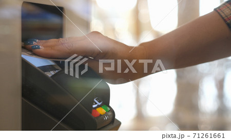Close up hands of woman making payment with credit card machine terminal. Woman paying with contactless credit card with NFC technology. Wireless money transaction. Wireless payment 71261661