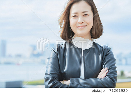 屋外で笑顔を見せるオフィスカジュアルスタイルの女性 屋外で笑顔を見せるオフィスカジュアルスタイルの女性 71261929