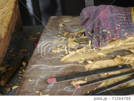 PUTRAJAYA, MALAYSIA - DECEMBER 07,2017: A man is carving wood using traditional hand tools. Carvings based on flora motifs 71264788