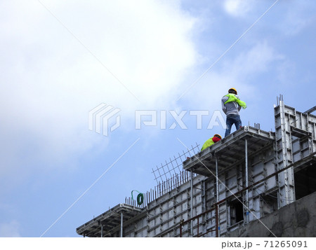 KANGAR, MALAYSIA -JULY 31, 2017: Construction workers working at height without wearing proper safety gear like body harness. This dangerous act can cause accidents and death. 71265091