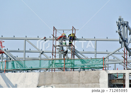 KANGAR, MALAYSIA -JULY 31, 2017: Construction workers working at height without wearing proper safety gear like body harness. This dangerous act can cause accidents and death. 71265095